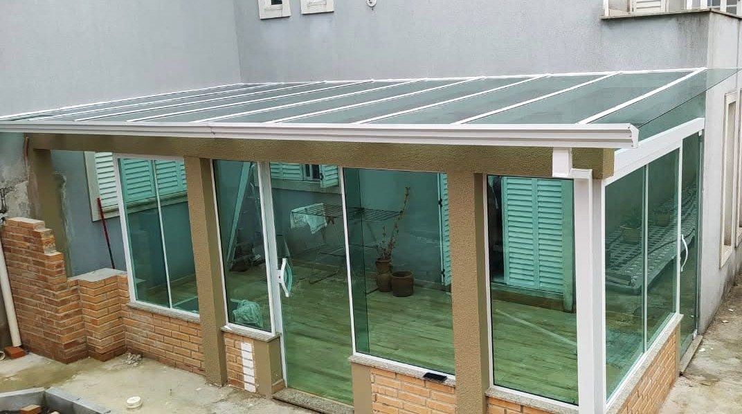 Cobertura e fechamento de vidro em área externa